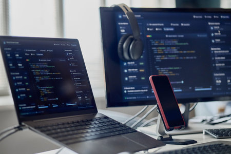 Close up of laptop, monitor, smartphone displaying software code in information technology office. Supporting app development, programming, cybersecurity, digital workflow