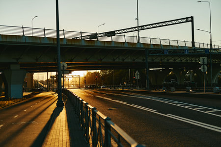 Empty city highway and overpass bridge during sunset, representing urban infrastructure and transportation. Ideal for logistics, civil engineering, and modern city development campaigns