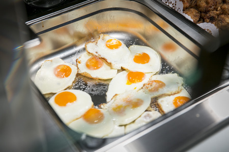 Fried eggs in stainless steel panの写真素材