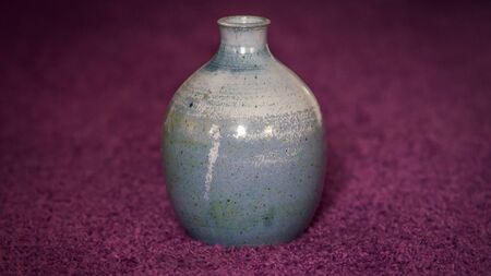 A vase on a purple carpet.の写真素材