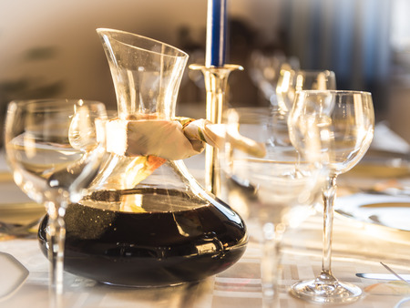 A table with wine glasses, dishes and plates for a celebration.の写真素材