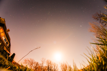 A glowing moon and stars in the night cope.の写真素材