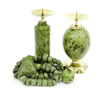 Candle holders, necklaces and a brooch made of stone serpentine  isolated on whiteの写真素材