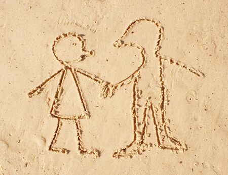 Drawing on the wet sand. Man and womanの写真素材