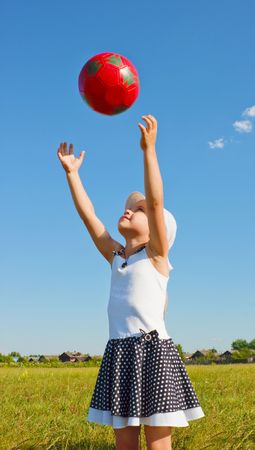 The little girl on the lawn playing with the ballの写真素材
