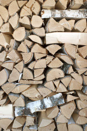 Birch logs are stacked in high woodpile. Backgroundの写真素材