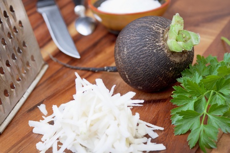 Black radish rub on a small grater for salad preparationの写真素材