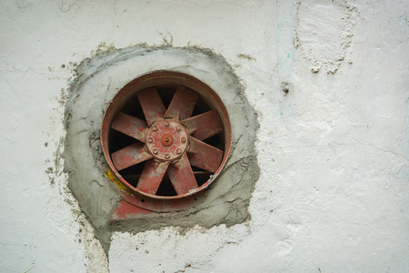 Old rusty fan inserted into the wall, not workingの写真素材