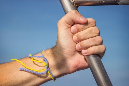 Hand on handrail in ship against the sky