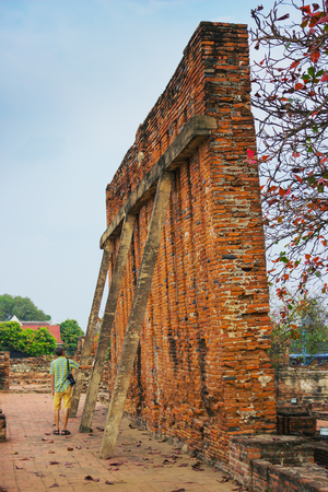 Tourist visits the ruins of an ancient monastery, Thailandの写真素材
