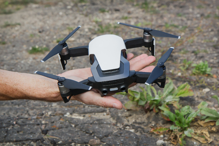 Unmanned aircraft with four rotors in the person's hand is ready for launch