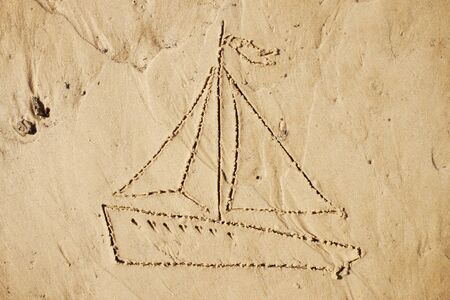 Yacht was depicted in the sand. Drawing on the sandy shoreの写真素材