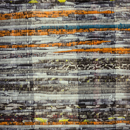 Handmade doormat from strips of cloth as background. Texture of a homespun rugの写真素材