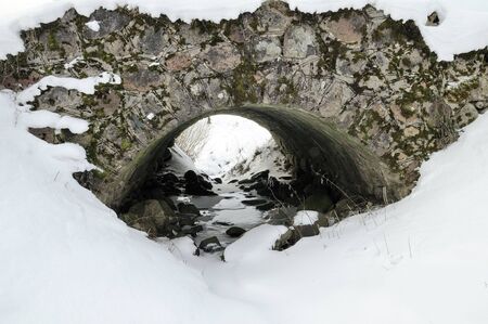 The rural bridge through a stream in the winter, January cloudy morningの写真素材
