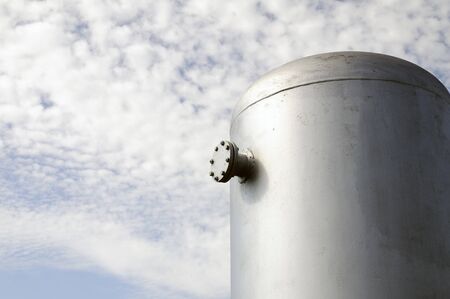 The fire-prevention tank shined with the sun against the cloudy skyの写真素材