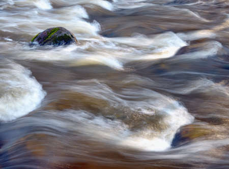Water rushing,  boulder in a river