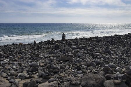 Cairns on a rocky seashoreの写真素材