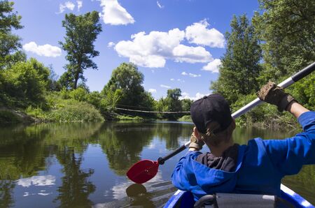 A teenager is kayaking on the riverの写真素材