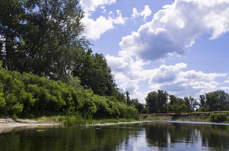Quiet river with deciduous trees on the banksの写真素材