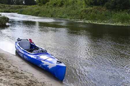 Kayak by the sandy bank of the riverの写真素材
