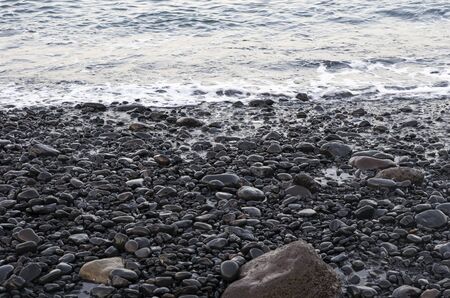 Sea surf on a black volcanic beachの写真素材