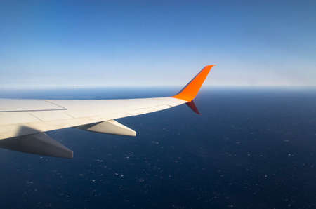 Airplane wing flying over the oceanの写真素材