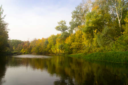 Autumn river landscape with trees on the bankの写真素材