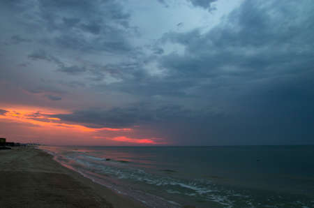 Sunset over the sea in cloudy weather, landscapeの写真素材