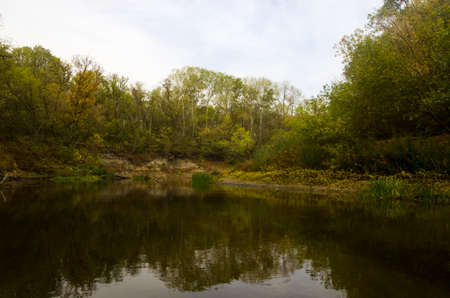 Autumn landscape of the river with trees on the bankの写真素材