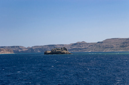 Stone island in a bay with rocky shoresの写真素材