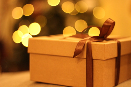 close-up open and closed gift box with brown ribbon bow on vintage top with defocused small colorful lights bokeh on Christmas tree background, surprise in christmas night partyの写真素材