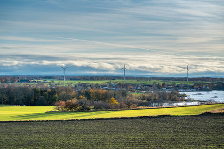 Green fields and autumn colour with electric windmills in backgroundの写真素材