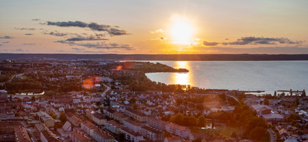 Great Panorama Skyline view from above Huskvarna city and Lake Vattern during magical warm reflecting Sunset over lake near Jonkoping, Sweden.の写真素材