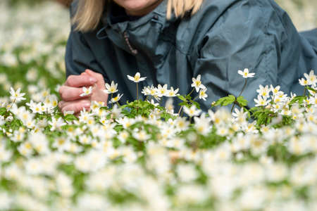 Woman lying down in Flower bed or field with Hiking casual clothing,の写真素材