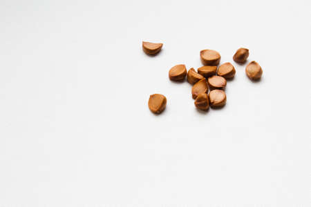 Ripe iris seeds. Scattered on the surface of the table. Space for text.