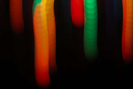 Abstract bokeh-style background on a dark background with blur. Movement of lights. Concept: advertising banner, show, holiday, background, screensaver, wallpaper.の写真素材