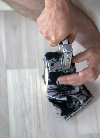 The process of replacing upholstery with furniture parts. Mens hands work with a steppler. Fixes the...
