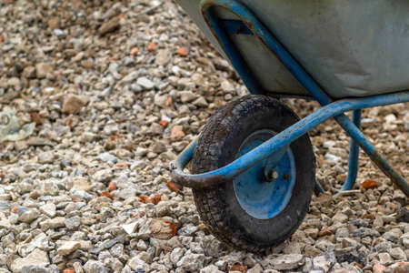 Trolley for building material. Distribution of rubble on the road. Concept: construction, road repairs, sale of crushed stone, backgrounds and textures, working tools.の写真素材