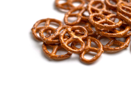 Crispy salty pretzels lie scattered on a white background. Top view. Concept: quick snack, food photography, holidays and vacations, cafes and bistros, Christmas food.の写真素材