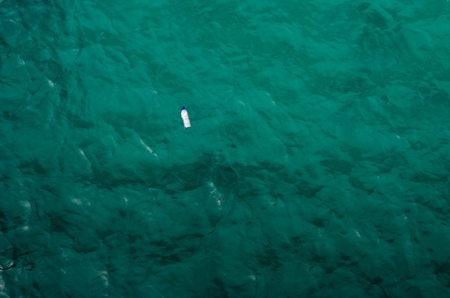 Single plastic bottle in the ocean
