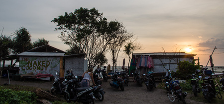 BALI, BERAWA BEACH, INDONESIA MARCH 2017: Local beach bar "Naked Coconut" at sunset time from car park with many scooters and beach in the backgroundのeditorial素材