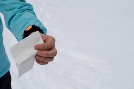 Woman holding a handkerchief in her left arm in winter with lots of free space on the right sideの写真素材
