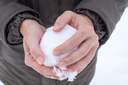 Ready for a snowball fight? Close-up of handy creating a snowball.の写真素材