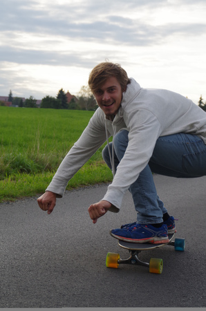 Young Man on longboard going down the street.の写真素材
