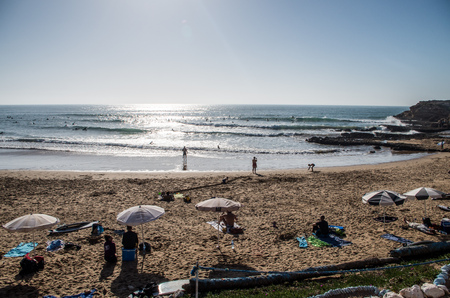 People relaxing at the beach and surfing the waves at surf spot called Devils Rock in Morocco, January 2018.のeditorial素材