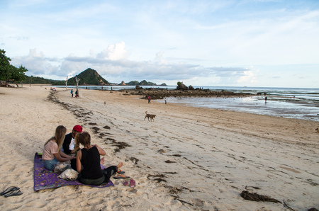 View along Kuta beach with a group of people chilling at Kuta Beach, Lombok, Indonesia, March 2017.のeditorial素材