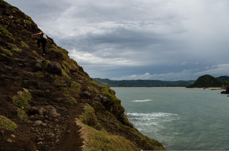 Woman climbing hill at Seger Beach, Lombok.の写真素材