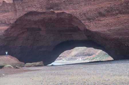 Man taking photos from under Legzira rock formation.の写真素材