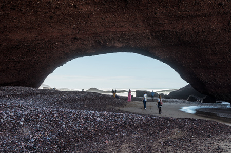 People are fascinated by the epic rock formation at Legzira beach in February 2018, Legzira, Morocco.のeditorial素材