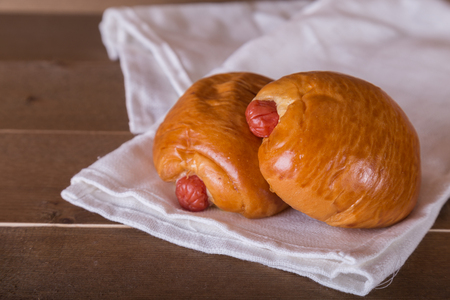 two sausage breads on white linen  wooden backgroundの写真素材